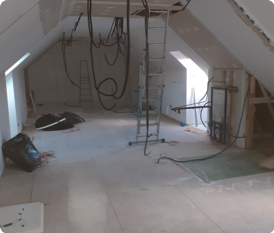 Combles en rénovation avec câblage suspendu et échelles, travaux en cours