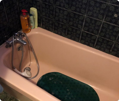 Baignoire rose avec murs carrelés avant remplacement