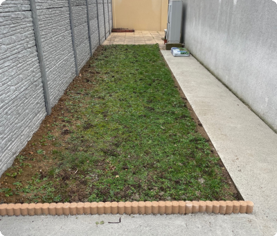 Allée bétonnée et clôture moderne après aménagement