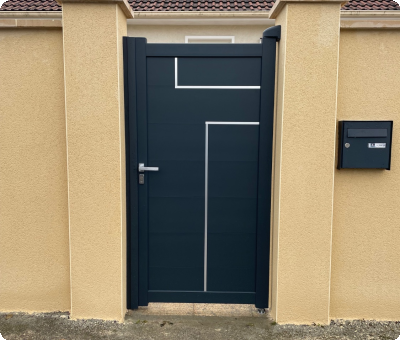 Portillon noir et moderne installé entre piliers en crépi beige après travaux