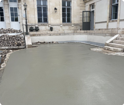 Béton frais coulé devant un bâtiment en cours de travaux à Gien