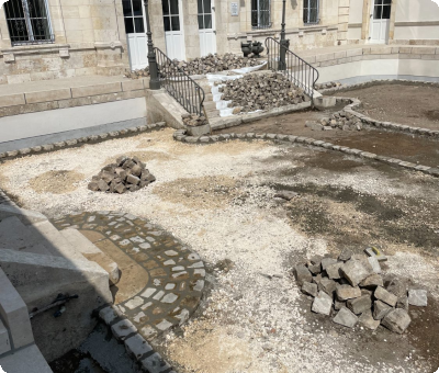 Pavés en calcaire en cours de pose devant un édifice à Gien