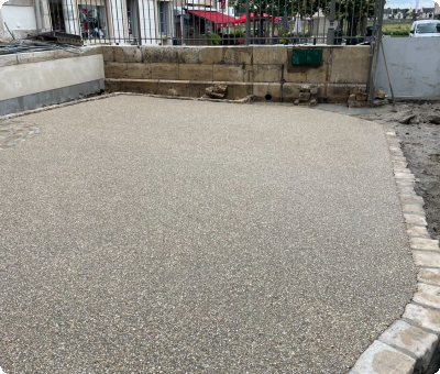 Place rénovée en béton désactivé entourée de pavés à Gien après travaux