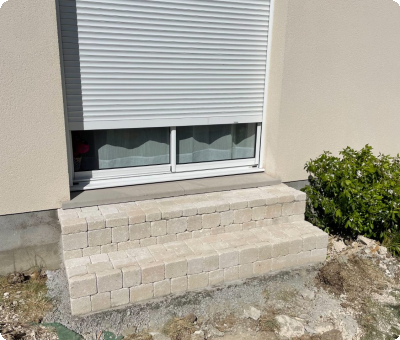 Perron en pavés terminé devant une fenêtre après travaux