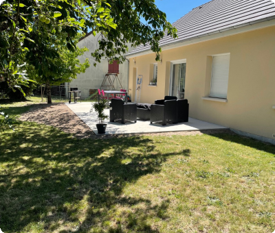 Terrasse en béton terminée avec mobilier, jardin verdoyant, après travaux
